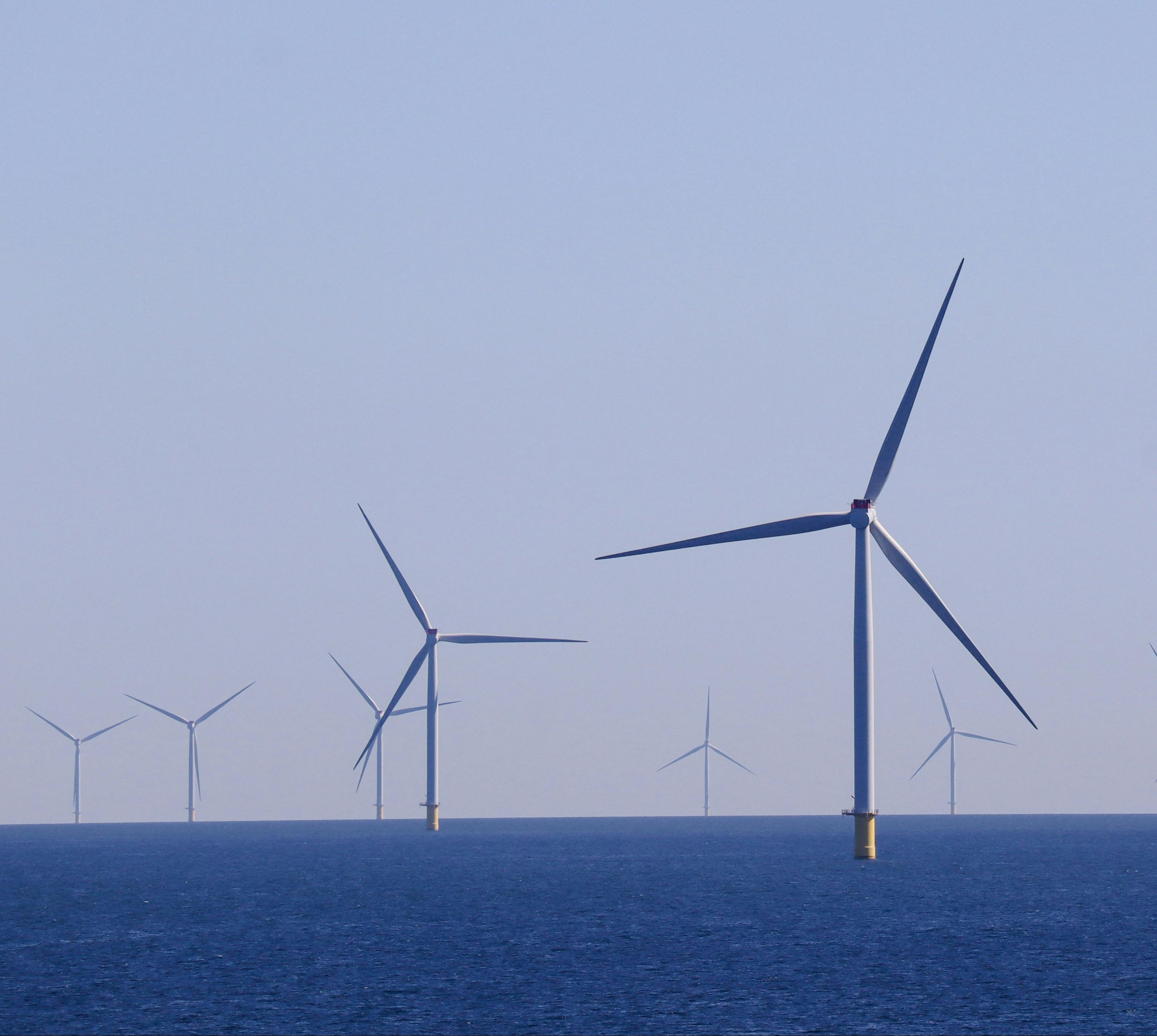 A series of offshore wind turbines generating renewable energy in a vast ocean landscape